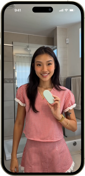 Juni app on a phone, held by a smiling customer in her bathroom